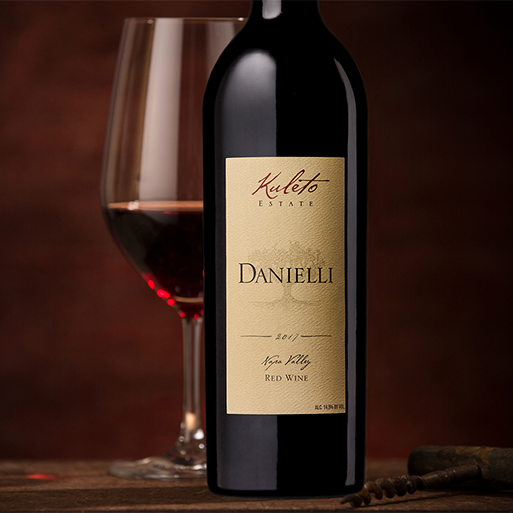 A bottle of Kuleto Danielli Red Blend next to a poured glass of the wine