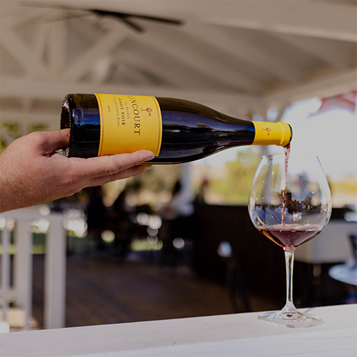 Tabletop scene with Lincourt wine and red wine being poured on an outdoor patio