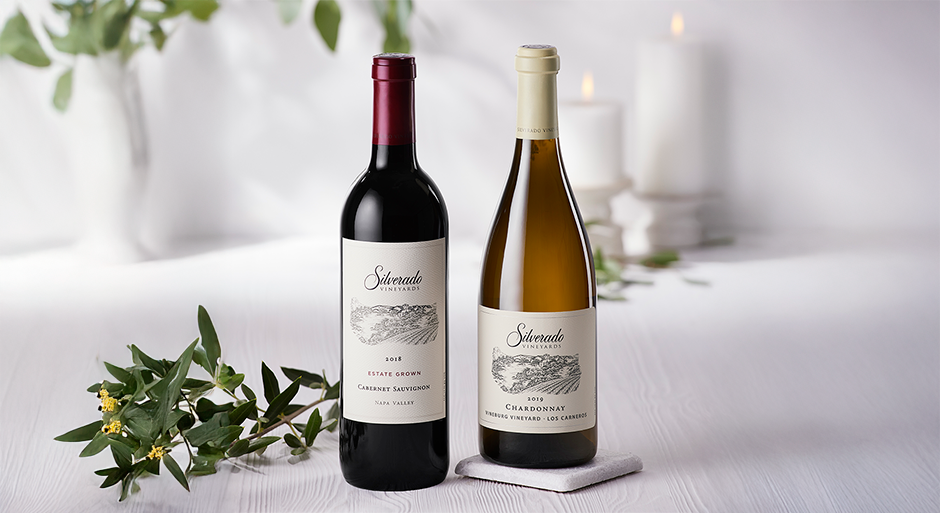 two bottles of silverado wines on a white background with some flowers and candles in the background